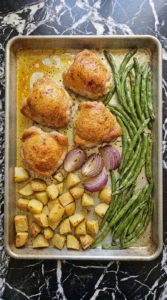 Sheet Pan Chicken Thighs and Veggies for Busy Weeknights step 4 with amber chicken thighs, golden potatoes and blistered green beans
