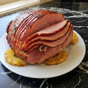 Crockpot Thanksgiving Ham with glossy glazed spiral slices on a serving plate Recipe focus: thanksgiving ham recipes crockpot.