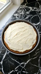 Friendsgiving Cake frosting layer being spread over cake Recipe focus: friendsgiving cookies.