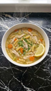Finished Gluten Free Chicken Noodle Soup with rotini, chicken, carrots and fresh parsley