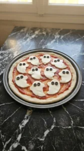 Halloween Appetizers Pizza dough base with tomato sauce before toppings