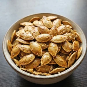 Roasted Pumpkin Seeds with Parmesan piled in a ceramic bowl with crisp bronze edges and fine Recipe focus: how to make roasted pumpkin seeds with parmesan.