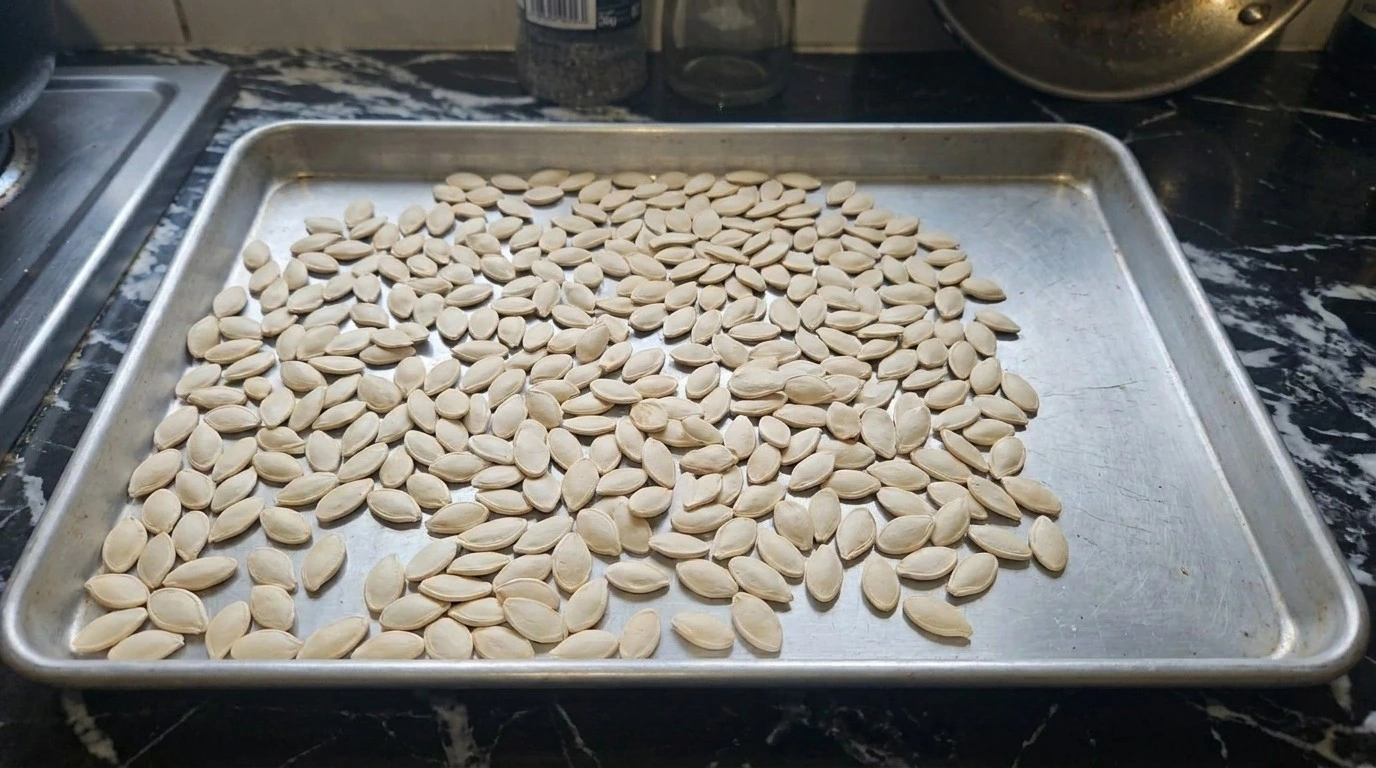 Roasted Pumpkin Seeds with Parmesan step two showing pale pumpkin seeds dried until matte before seasoning Recipe focus: toasted pumpkin seeds.