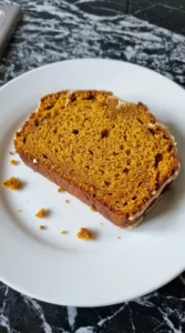 Brown Butter Pumpkin Bread slice showing moist orange crumb, spice flecks, copper crust and a thin layer of icing Recipe focus: pumpkin bread with icing.