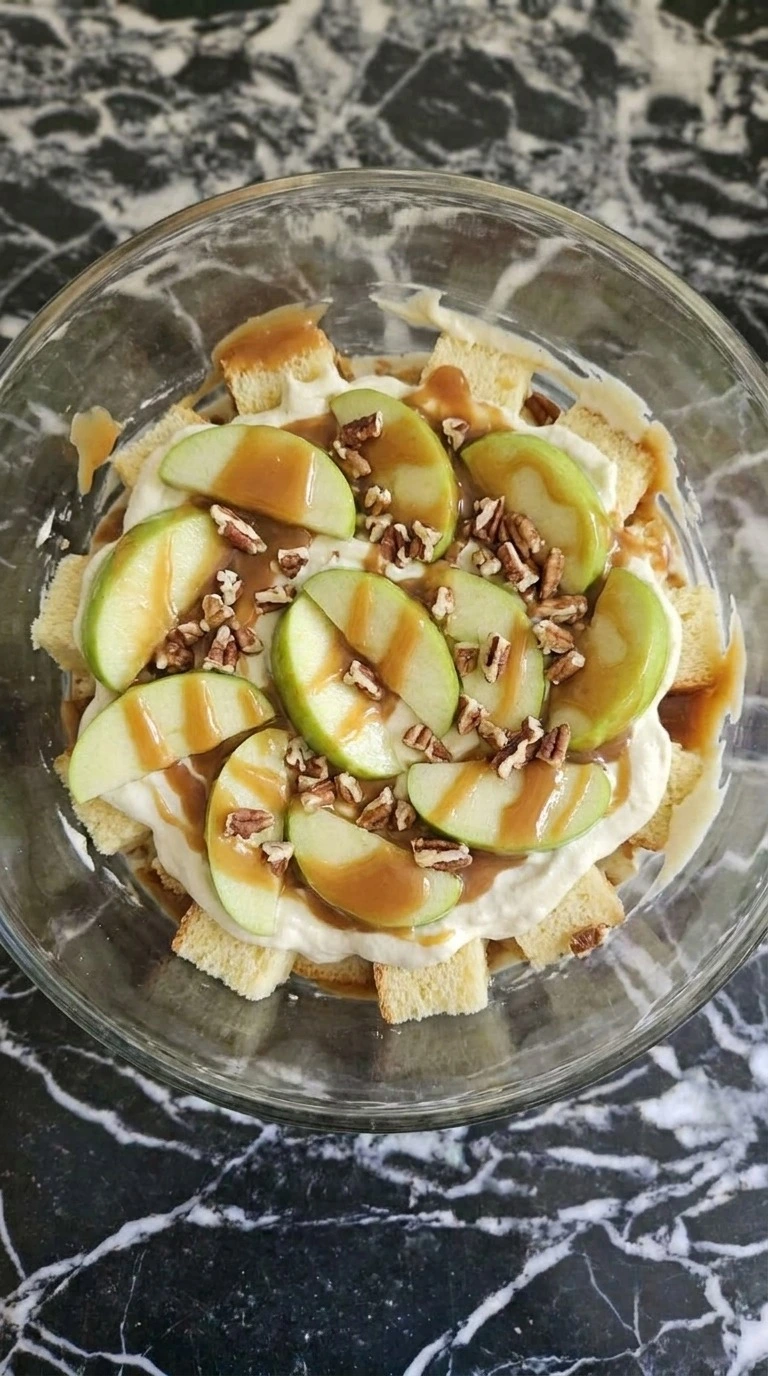 Layering Carmel Apple Trifle Fall Desserts with cake, cream, apples, caramel and pecans
