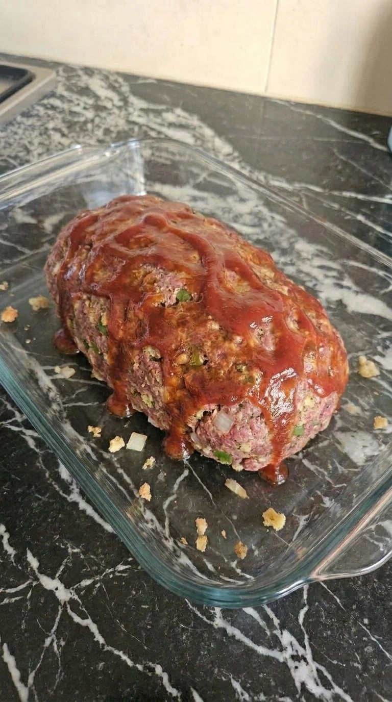 Cracker Barrel Meatloaf baking with browned glaze and firm edges Recipe focus: meatloaf with stove top stuffing.