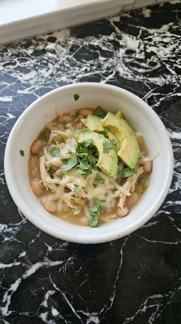 Crockpot White Chicken Chili served with cheese cilantro and avocado Recipe focus: chicken chili recipe.