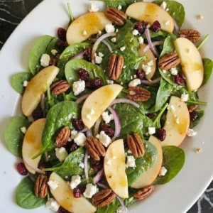 Fall Apple Salad with Honeycrisp slices, feta, toasted pecans and cranberries on a white serving platter Recipe focus: apple fall salad.