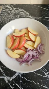 Fall Apple Salad Honeycrisp apple slices with lemon and thin red onion in a white prep bowl Recipe focus: autumn fruit salad.