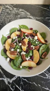 Fall Apple Salad partly folded with spinach, Honeycrisp apples, feta, pecans and cranberries Recipe focus: easy fall salad recipes.