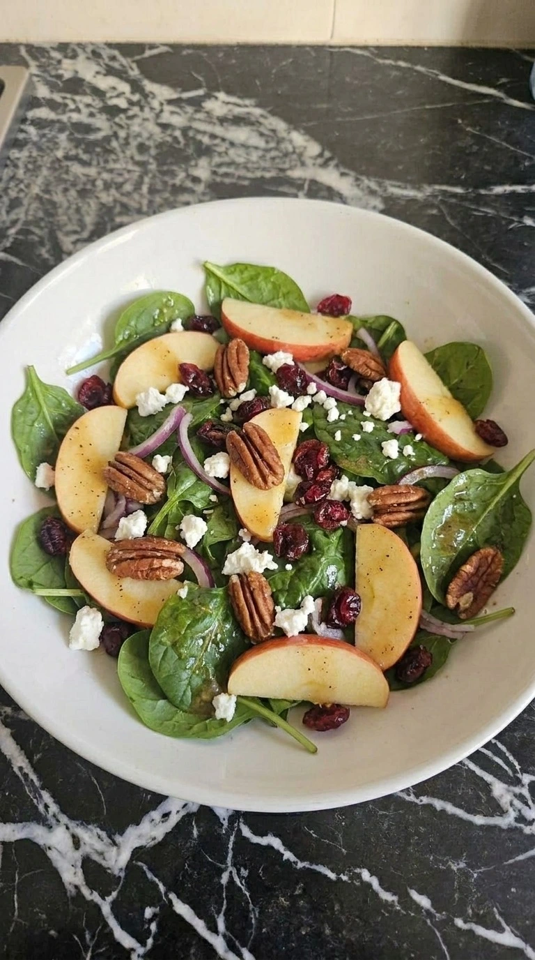 Fall Apple Salad partly folded with spinach, Honeycrisp apples, feta, pecans and cranberries Recipe focus: easy fall salad recipes.