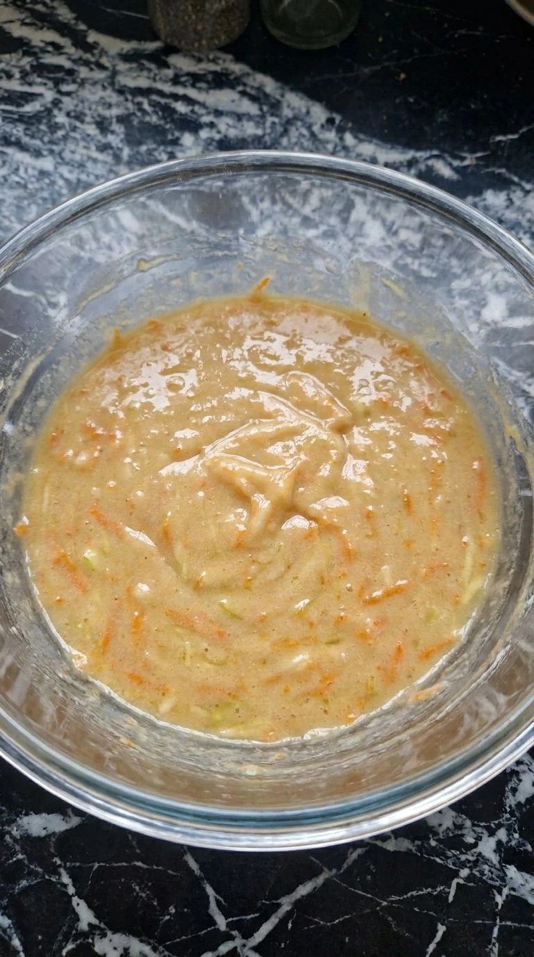 Grating apple and carrots into the wet mixture for Fall Desserts for People Who Hate Pumpkin