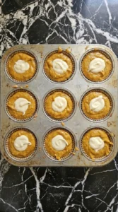 Fall Desserts with Cream Cheese step showing pumpkin muffin cups filled around white cream cheese centers