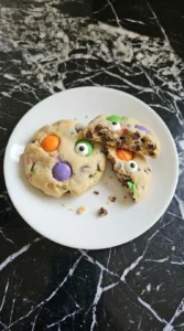 Halloween Cake Mix Cookies cooled with candy eyes and one cookie broken open to show the soft center Recipe focus: halloween cake mix cookies recipes.