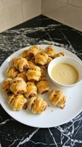 Halloween Cocktail Party Appetizers plated with golden mummy bites and pale Dijon yogurt dip