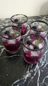 Halloween Cocktails finished with club soda bubbles, three blackberries and rosemary in each black-rimmed rocks Recipe focus: easy halloween cocktails recipes.