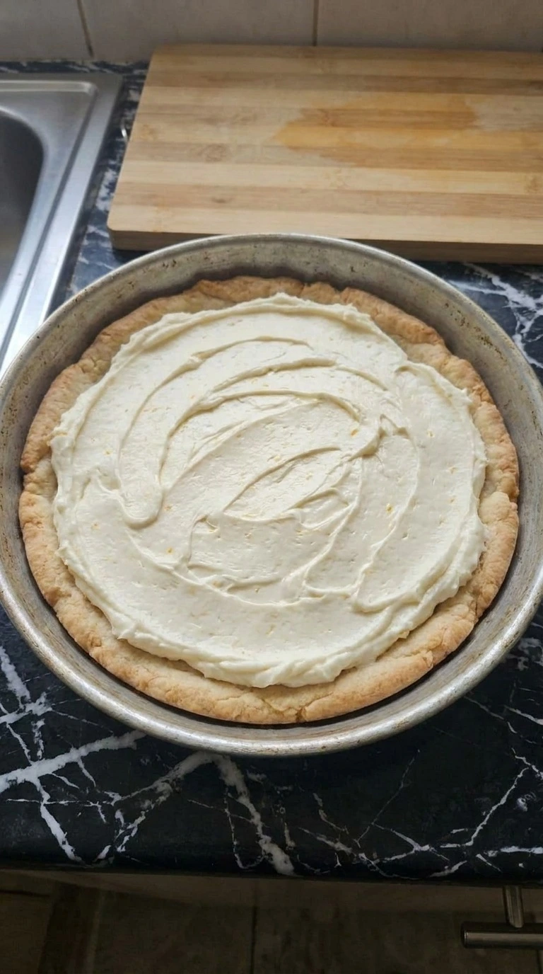 Halloween Fruit Pizza Sugar Cookie topped with a thick swirled cream cheese layer and golden border