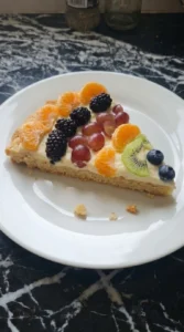 Halloween Fruit Pizza Sugar Cookie wedge showing soft cookie crust, cream cheese layer and fresh fruit