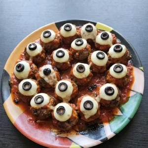 Halloween Party Food Meatballs with beef, marinara, mozzarella eyes and black olive pupils on a platter