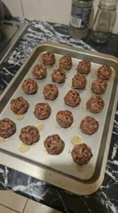 Halloween Party Food Meatballs with 16 beef meatballs baked to dark brown speckles on a tray
