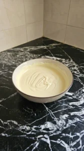 Melting white chocolate for Halloween Party Food Pretzels until smooth, glossy and free of dry wafers