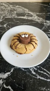 Halloween Peanut Butter Spider Cookies step 5 finished with piped chocolate legs and two candy eyes on each cookie