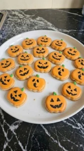 Halloween Pumpkin Painting finished cookies with varied black faces and green stems on orange icing Recipe focus: pumpkin painting ideas halloween.