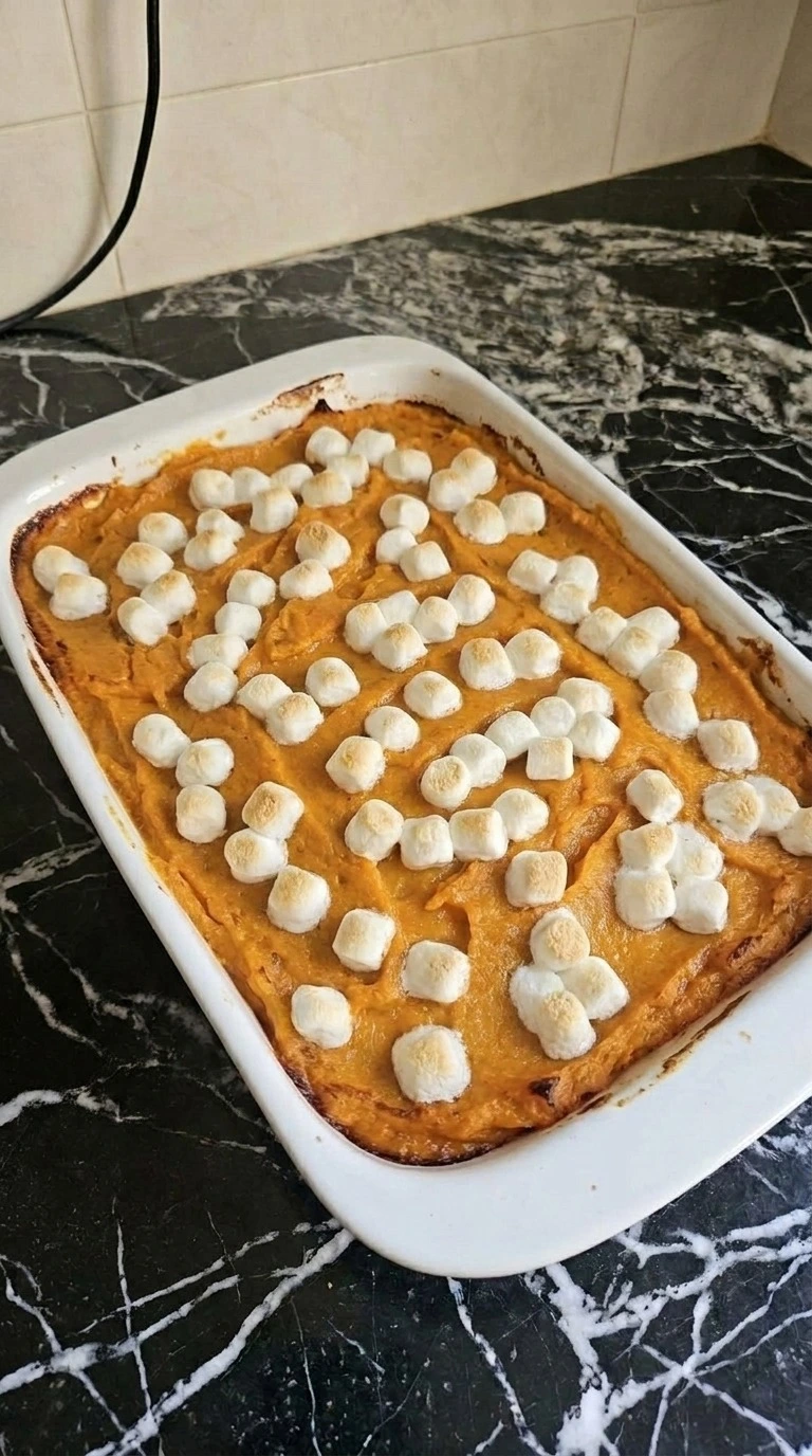 Sweet Potato Casserole with Marshmallows topping browning in baking dish Recipe focus: easy sweet potato casserole.