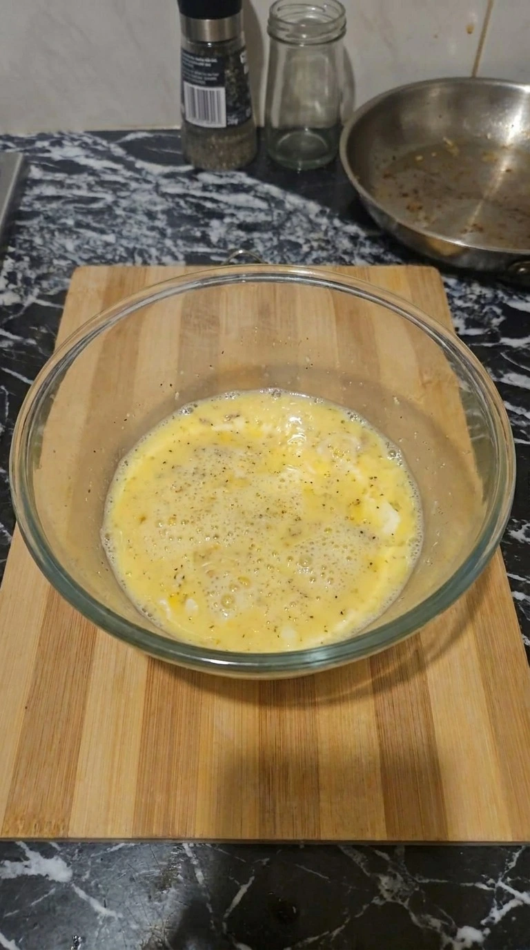Tater Tot Breakfast Casserole egg mixture being whisked in bowl Recipe focus: breakfast casserole with hashbrowns.
