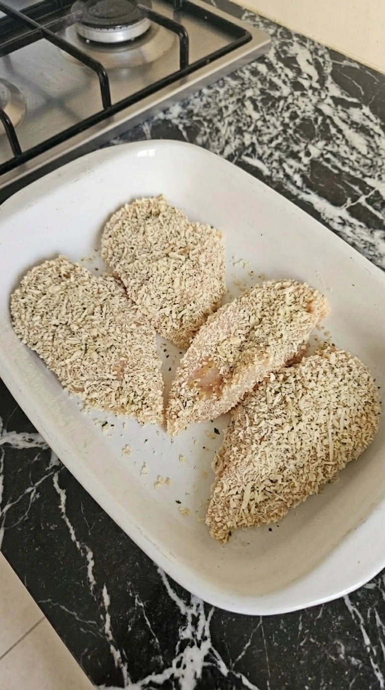 Four Chicken Parmesan cutlets coated in Italian-seasoned panko and grated Parmesan before frying. Recipe focus: easy chicken parmesan.