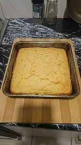 Cornbread Dressing preparation showing homemade cornbread baked golden in a square pan Recipe focus: easy cornbread dressing.