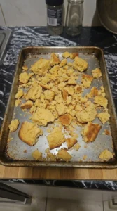Cornbread Dressing preparation with coarse golden cornbread crumbs spread on a baking sheet Recipe focus: cornbread dressing recipe.