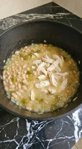 Creamy White Chicken Chili with shredded chicken and partially mashed Great Northern beans thickening the broth Recipe focus: crockpot white chicken chili.