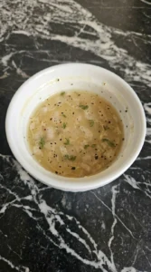 Fall Salad Dressing served in a white sauce bowl with thyme, shallot and pepper visible Recipe focus: best salad dressing.