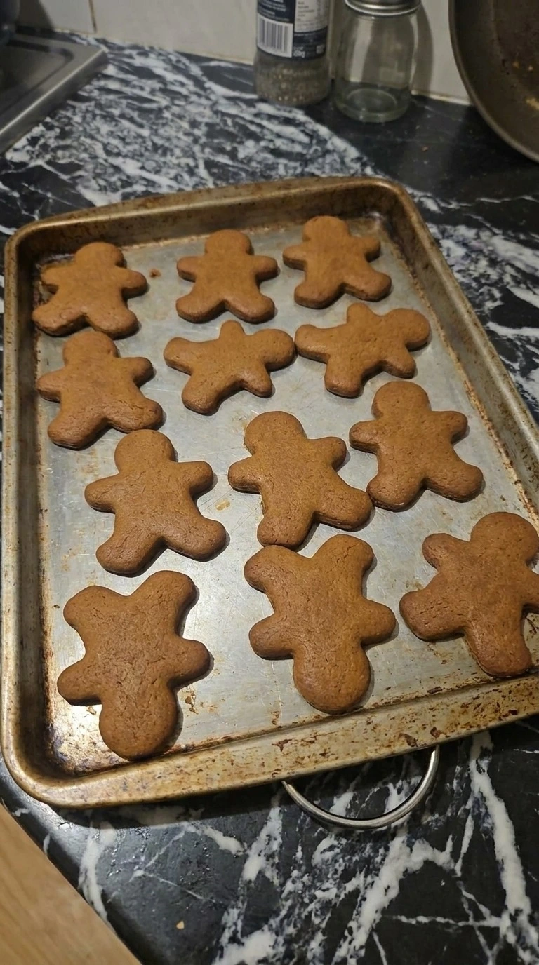 Gingerbread Man Cookies baking with golden edges on a tray Recipe focus: gingerbread cookies decorated.