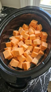 Raw sweet potato cubes with water and sea salt inside a slow cooker for Slow Cooker Mashed Sweet Recipe focus: slow cooker mashed sweet potatoes recipe.