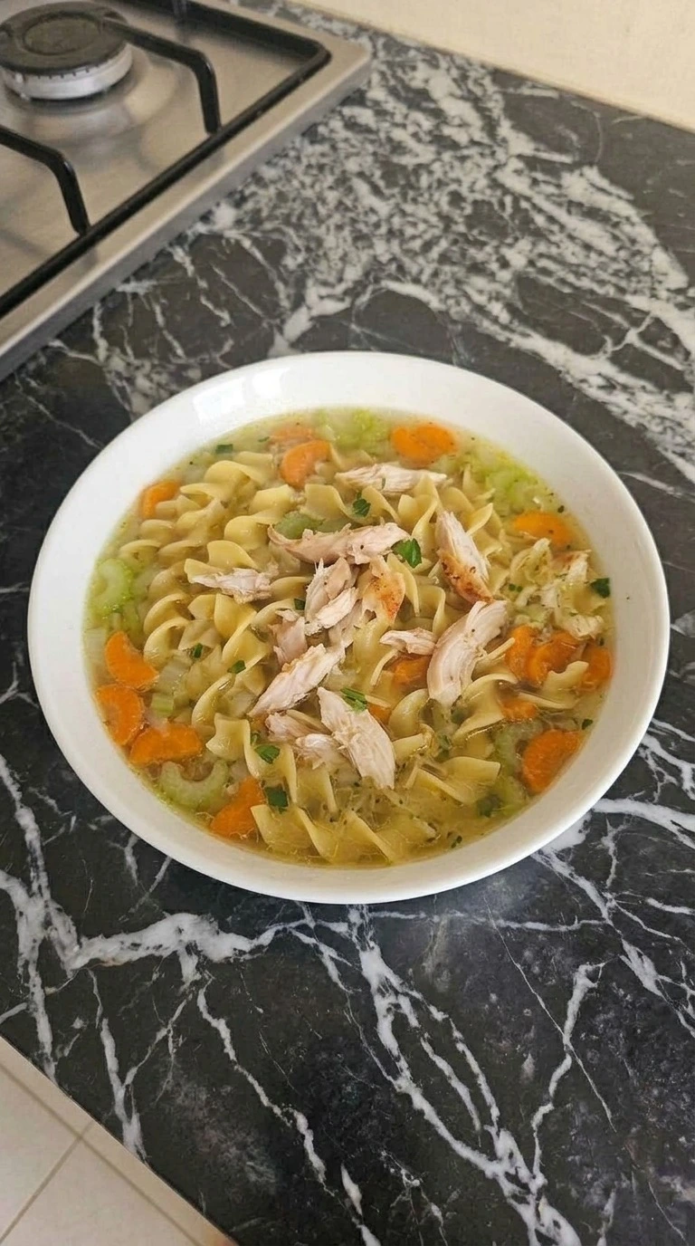 Turkey Noodle Soup served in a white bowl with tender turkey, golden noodles, carrots and fresh parsley. Recipe focus: easy turkey noodle soup.